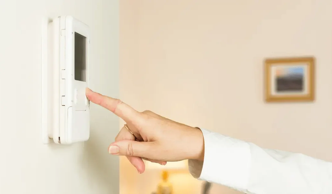 finger reaching the button to turn on thermostat