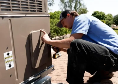 Professional HVAC technician from Falcon Air Conditioning inspecting and maintaining a residential air conditioning unit to improve efficiency and performance.