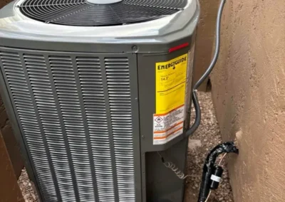 Outdoor AC condenser installed beside a Mesa, AZ home